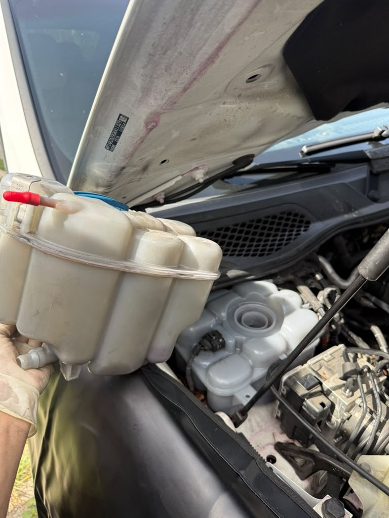 Old and replacement Porsche coolant expansion tanks